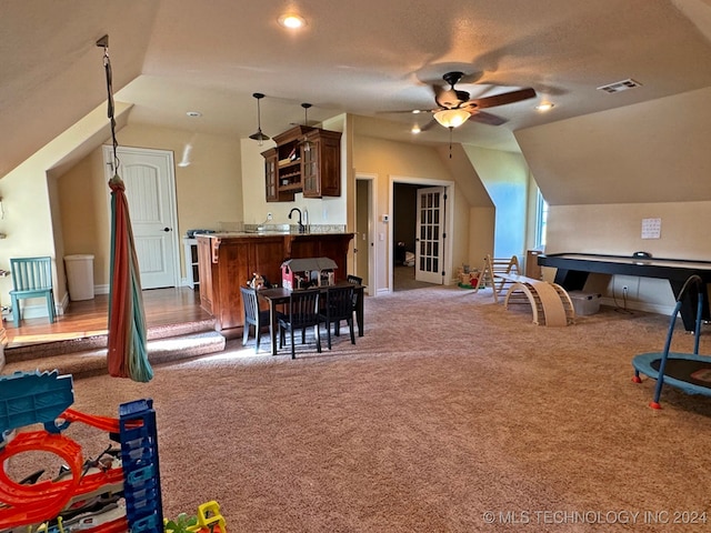 game room with lofted ceiling, dark carpet, and ceiling fan