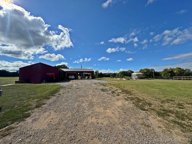 exterior space with a rural view, a yard, and a carport