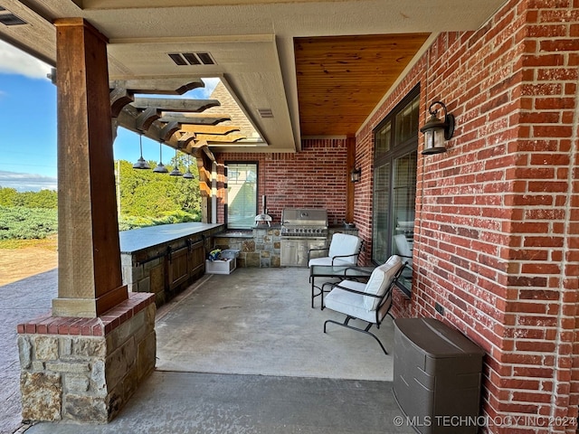 view of patio with an outdoor kitchen and a grill