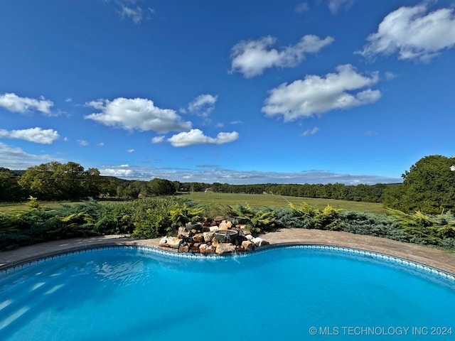 view of swimming pool featuring a rural view