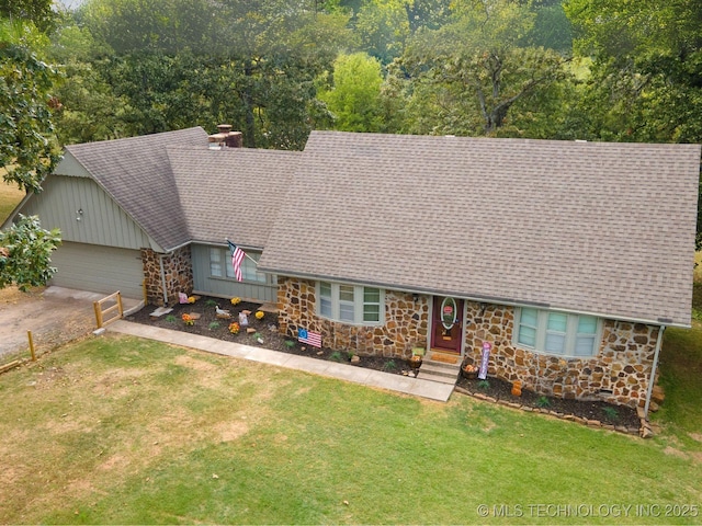 view of front of home featuring driveway, stone siding, an attached garage, and a front lawn