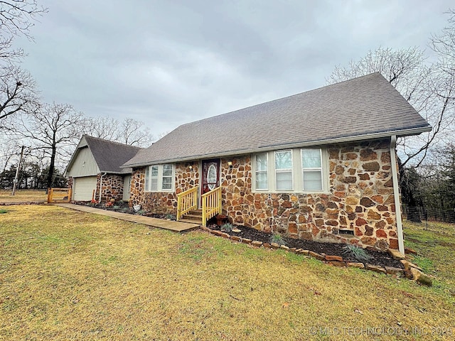 single story home with a garage, stone siding, a shingled roof, and a front lawn