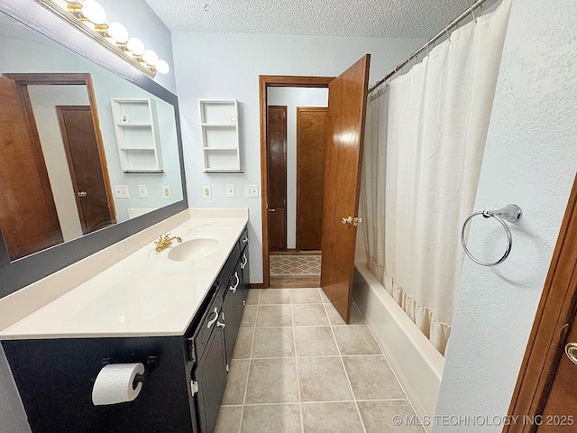 bathroom featuring tile patterned flooring, shower / bath combo with shower curtain, a textured ceiling, and vanity