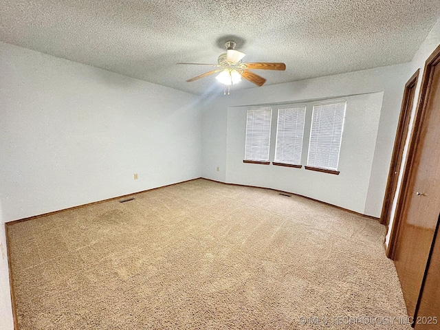 unfurnished bedroom featuring visible vents, carpet flooring, ceiling fan, a textured ceiling, and baseboards