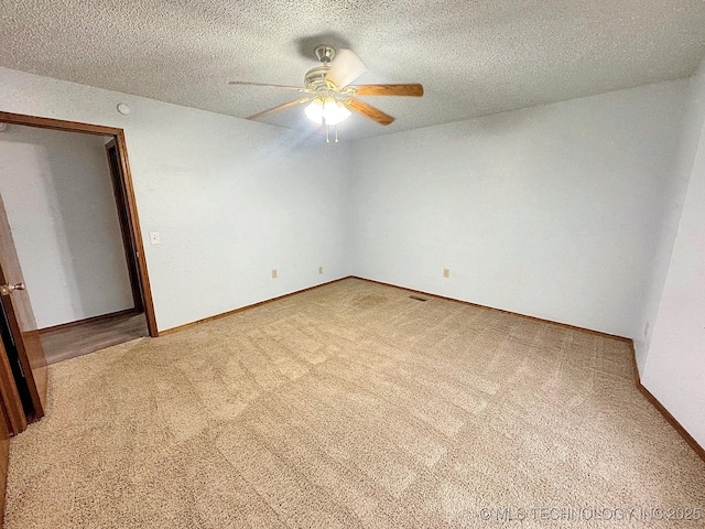 unfurnished room featuring baseboards, carpet, a ceiling fan, and a textured ceiling