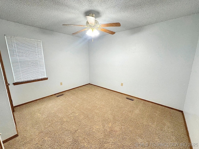 carpeted spare room with a ceiling fan, baseboards, visible vents, and a textured ceiling