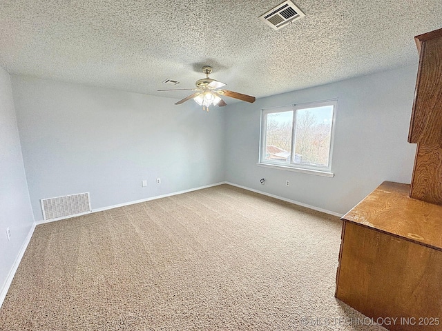 unfurnished room featuring a ceiling fan, carpet, visible vents, and baseboards