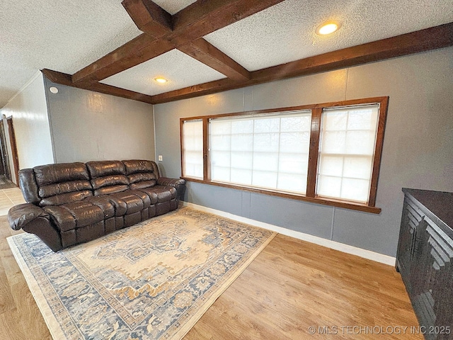 living area featuring beam ceiling, a textured ceiling, wood finished floors, coffered ceiling, and baseboards