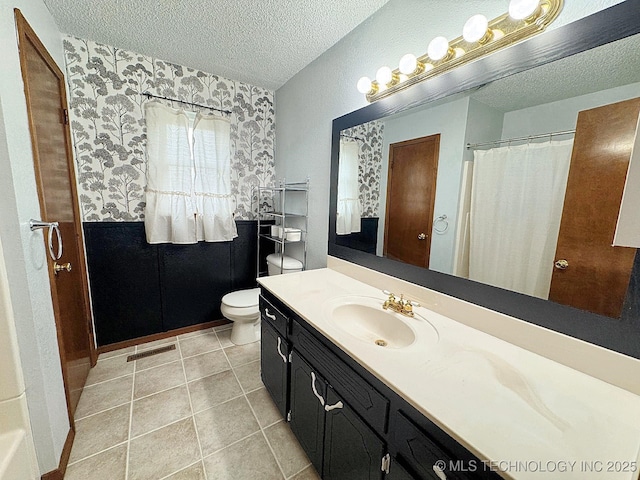 full bath with visible vents, toilet, tile patterned floors, a textured ceiling, and vanity