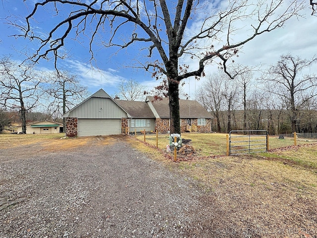 view of front of home with an attached garage, brick siding, fence, driveway, and a front yard