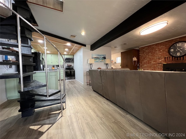 living room featuring beamed ceiling and light hardwood / wood-style flooring