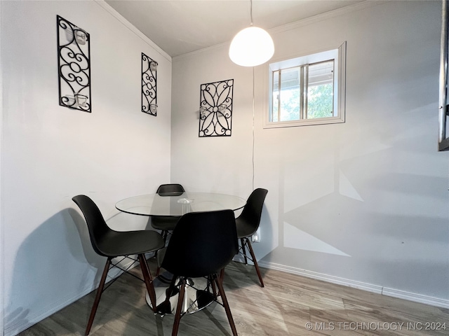 dining room with wood-type flooring and crown molding