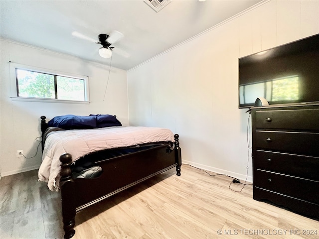 bedroom featuring light wood-type flooring, ceiling fan, and crown molding