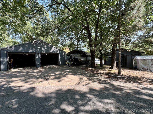 view of side of home featuring a garage, a carport, and an outbuilding