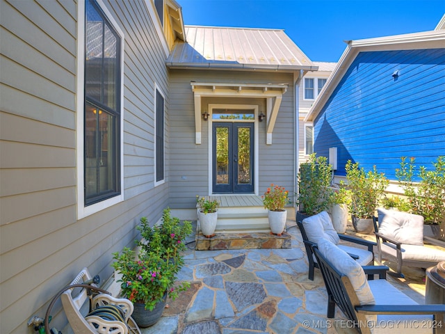 view of exterior entry featuring an outdoor living space, a patio area, and french doors