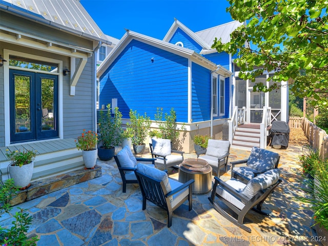 view of patio featuring an outdoor living space with a fire pit and french doors