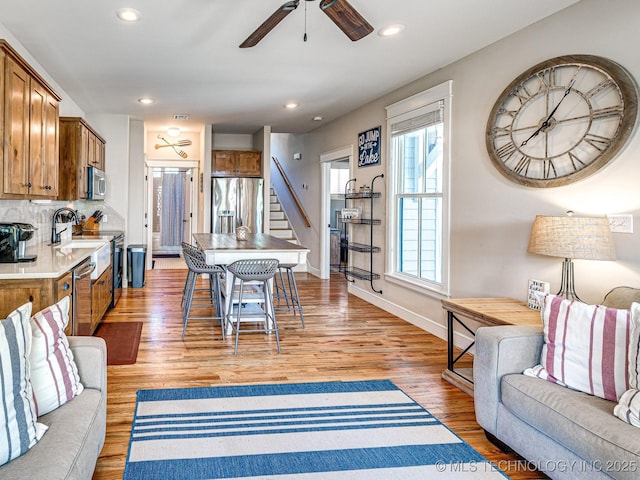 living room with light hardwood / wood-style floors and ceiling fan