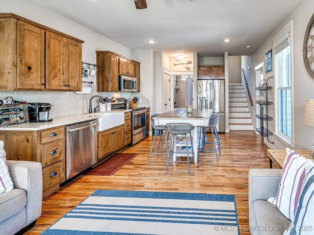 kitchen featuring a kitchen island, tasteful backsplash, appliances with stainless steel finishes, and light wood-type flooring