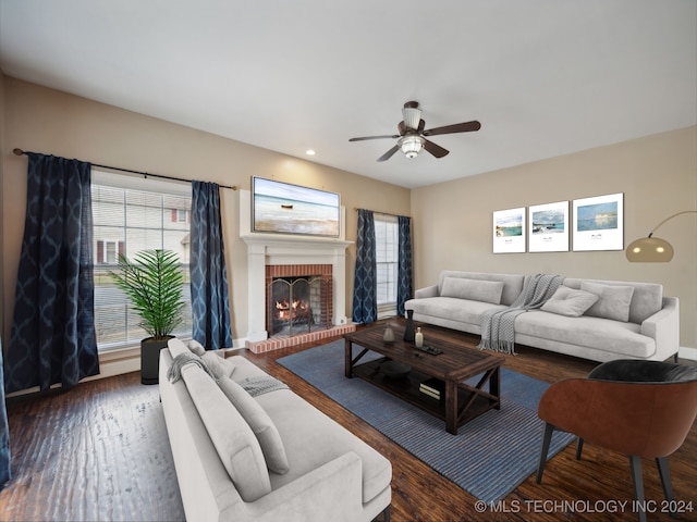 living room featuring ceiling fan, a fireplace, and dark hardwood / wood-style flooring