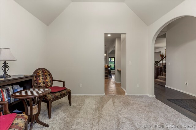 sitting room with vaulted ceiling and light carpet