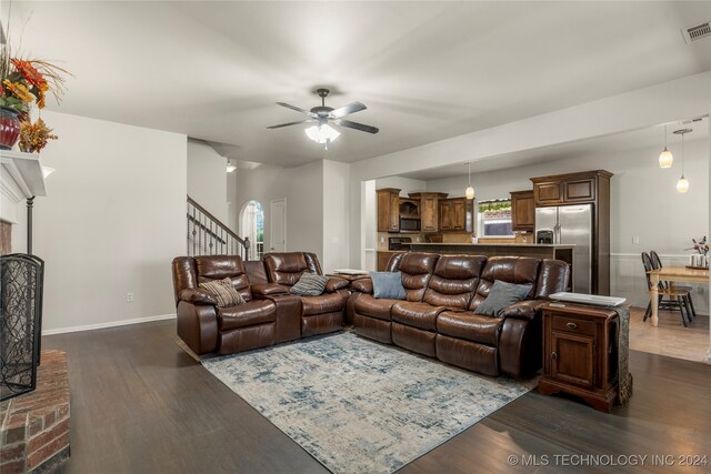 living room featuring ceiling fan and dark hardwood / wood-style flooring