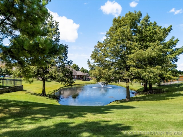 view of community with a lawn and a water view