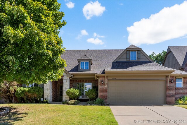 view of front of property with a garage and a front lawn