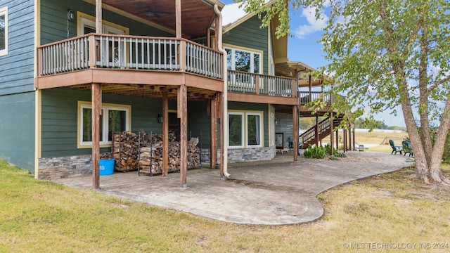 rear view of house featuring a yard, a deck, and a patio area