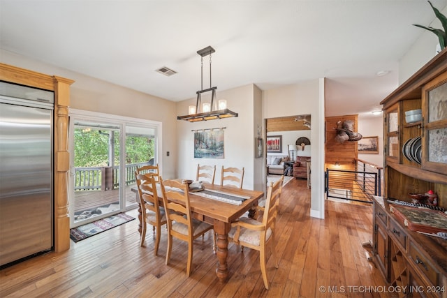 dining room with light hardwood / wood-style floors and an inviting chandelier