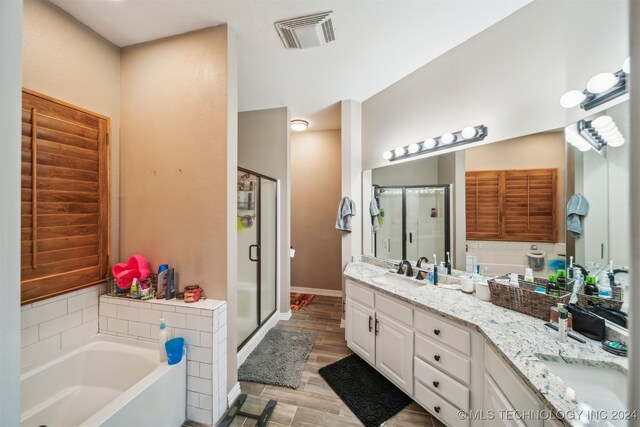 bathroom featuring hardwood / wood-style floors, vanity, and separate shower and tub