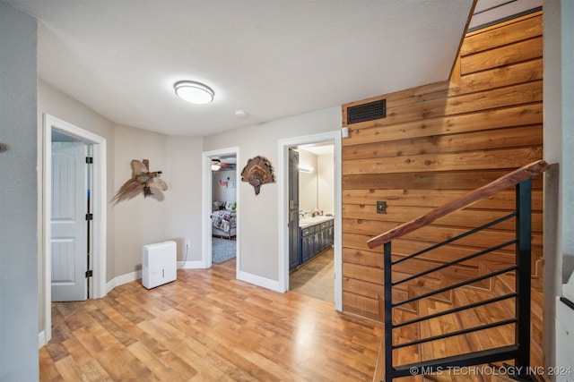 hall with a textured ceiling and light hardwood / wood-style flooring