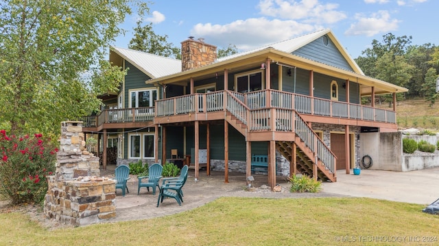 back of property with a patio area, a deck, and a yard