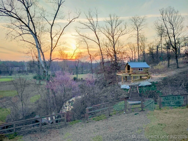 yard at dusk featuring a rural view