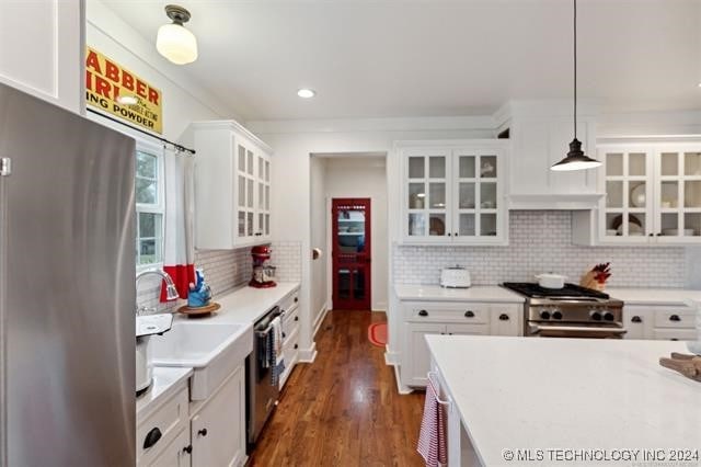 kitchen featuring white cabinetry, appliances with stainless steel finishes, hanging light fixtures, and dark wood-type flooring