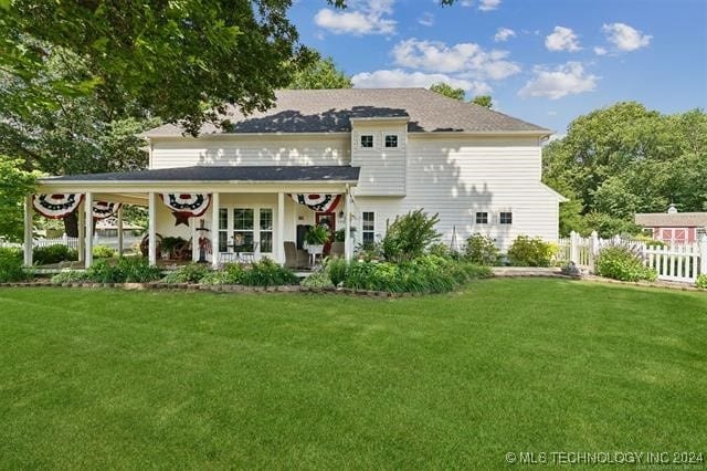 rear view of property featuring french doors and a lawn