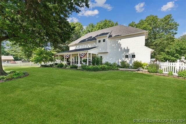 rear view of house featuring a lawn