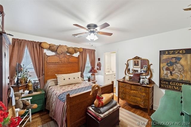 bedroom featuring wood-type flooring, ensuite bath, and ceiling fan