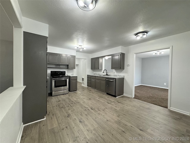 kitchen featuring appliances with stainless steel finishes, gray cabinetry, light hardwood / wood-style floors, and sink