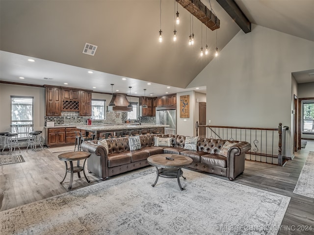 living room featuring beamed ceiling, sink, hardwood / wood-style floors, and high vaulted ceiling