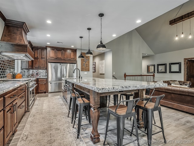 dining room with light hardwood / wood-style floors, sink, and high vaulted ceiling