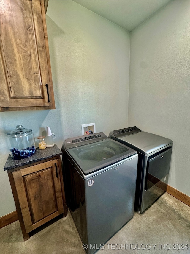 laundry room featuring cabinets, light colored carpet, and washer and clothes dryer