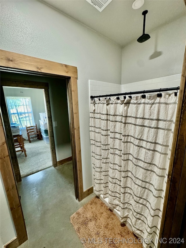 bathroom with a shower with curtain and concrete floors