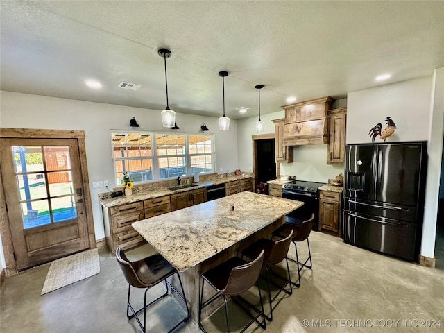 kitchen with a kitchen bar, a wealth of natural light, a center island, and stainless steel refrigerator with ice dispenser