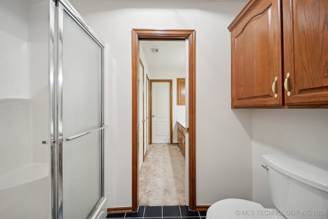 bathroom with toilet, vanity, tile patterned floors, and an enclosed shower