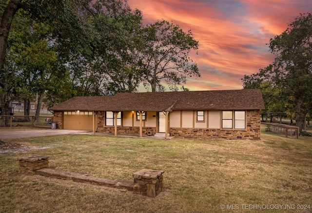 view of front of home featuring a garage, a porch, and a yard