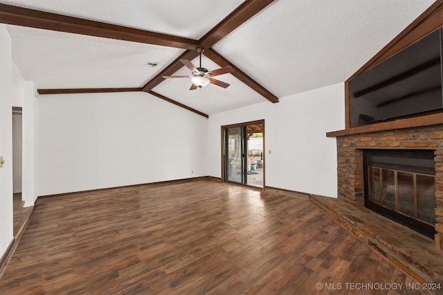 unfurnished living room featuring lofted ceiling with beams, ceiling fan, dark hardwood / wood-style flooring, a fireplace, and a textured ceiling