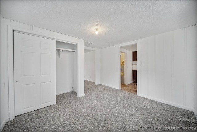 unfurnished bedroom featuring a closet, carpet, and a textured ceiling