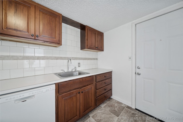 kitchen with a textured ceiling, backsplash, sink, and dishwasher