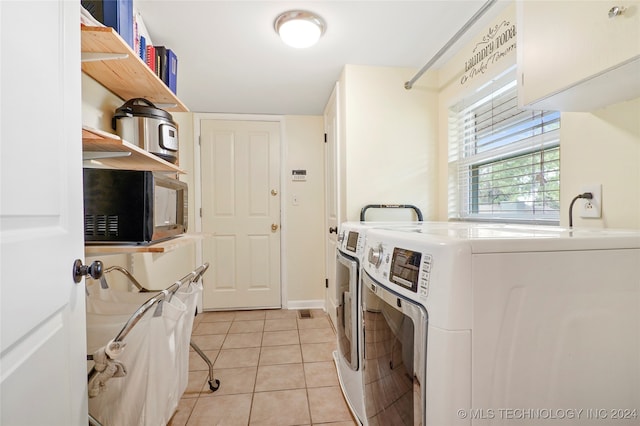 clothes washing area with light tile patterned flooring and separate washer and dryer