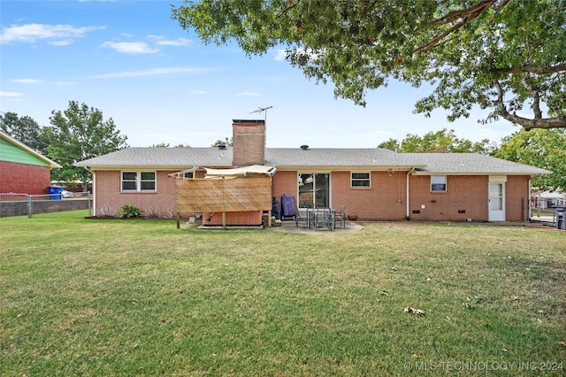 back of house with a lawn and a patio area